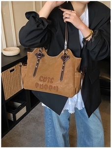 Close-up of brown suede tote bag with Cute Puppy embroidery and leather strap details