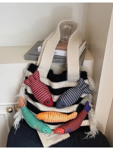 Knitted tote bag with black and white stripes featuring colorful knit fish charms