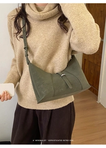 Detail of olive green crescent bag with retro matte texture and silver buckle