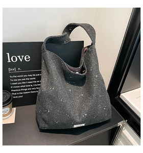 Detail of dark grey felt tote bag showing white star patterns and wide shoulder strap