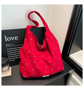 Close-up of red star print tote bag featuring fabric texture and bottom woven label