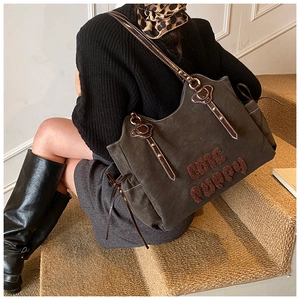 Detail of dark brown tote bag with cute puppy teddy fleece and leather strap