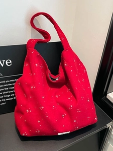 Large red canvas tote bag with white star pattern and wide shoulder strap for women