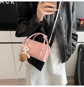 Pink leather handbag with bear charm shown in a stylish mirror selfie with model outfit