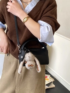 Minimalist black leather crossbody bag with a cute rabbit plush pendant for daily commuting