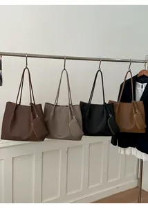 Série de quatre cabas en cuir grainé avec mini-pochettes assorties sur un support