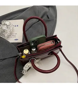 Internal view of burgundy patent leather bag showing phone, wallet and lipstick storage