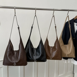 Hanging display of large hobo tote bags in four colors with metal ring decoration