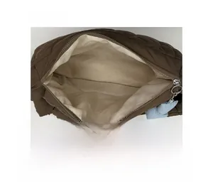 Dettaglio dell'interno della borsa trapuntata marrone con zip argento e ciondolo blu morbido