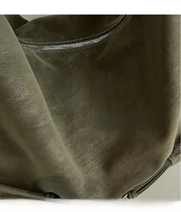 Detail of dark olive green tote with pebbled texture and white contrast stitching