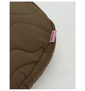 Dettaglio di borsa trapuntata marrone con un'etichetta tessuta rosa Fashion alla moda