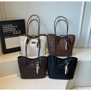 Group display of high-capacity tote bags in four colors with stylish beaded tassels