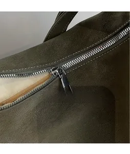 Detail of olive green tote bag featuring smooth metal zipper and premium faux leather texture