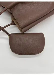 Vue détaillée du sac cabas en cuir marron foncé avec sa petite pochette assortie