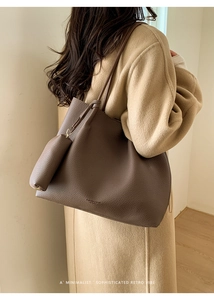 Détail du sac cabas vintage en cuir marron avec petite pochette sur manteau en laine
