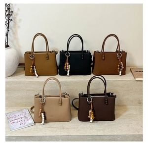 Detailed view of large tote bags in five colors with wooden bead charms and textured finish