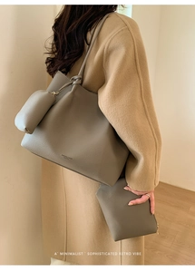 Détail d'un ensemble de sacs cabas gris en cuir grainé avec une petite pochette ronde