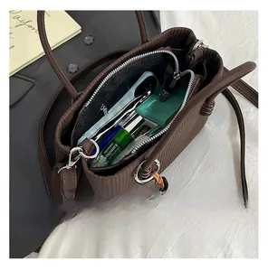 Macro view showing large internal capacity of the brown pleated tote bag with zipper pocket