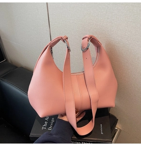 Detail of pink lychee leather handbag with silver rings and wide shoulder straps