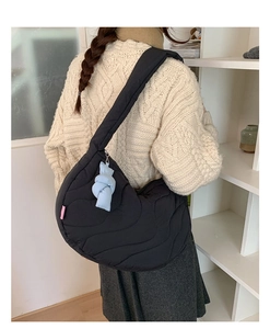 Quilted black crossbody crescent bag with thick shoulder strap and blue charm detail