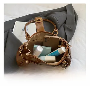 Macro detail of the spacious interior of a brown vintage leather bag with cosmetic items
