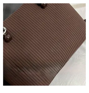 Detailed view of vertical pleated texture and embossed logo on coffee brown leather bag
