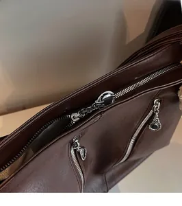 Détail du sac cabas en similicuir marron avec fermeture éclair argentée et tirette anneau