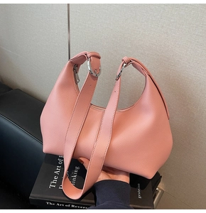 Close-up of pink litchi grain leather texture and silver hardware on a shoulder bag