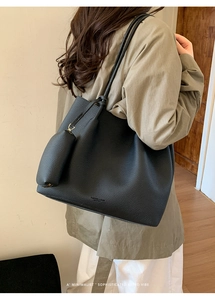 Détail du grand sac cabas en cuir noir grainé avec petite pochette porté à l'épaule