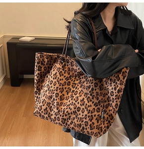 Detailed view of the leopard print canvas tote bag with slim brown shoulder straps