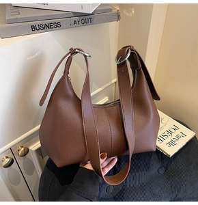 Detail of coffee brown pebble leather hobo bag with adjustable silver buckle straps