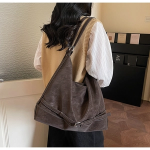 Dettaglio della borsa hobo in finto scamosciato color caffè con fibbia e tracolla larga