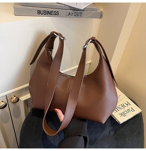 Detail of brown litchi pattern leather shoulder bag with adjustable silver buckle strap