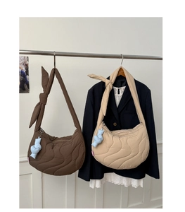 Quilted crescent dumpling bag in coffee and beige featuring knotted straps and wave stitching