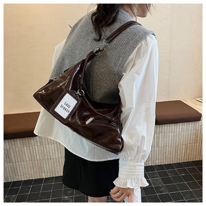 Close-up of deep coffee Hobo bag with glossy leather texture and side zipper pocket