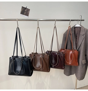 Detailed display of four colors of stylish large tote bags on a metal rack in an office setting