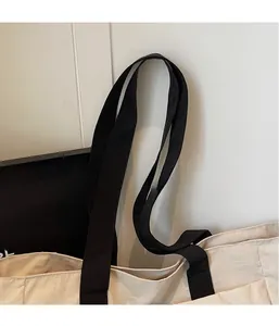 Detail of minimalist tote bag showing contrast stitching and durable handle attachment