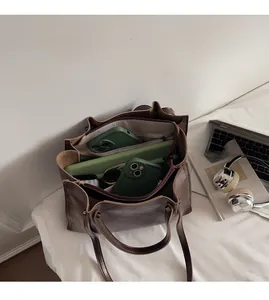 Macro view of a brown leather tote bag showing spacious interior and zip compartment