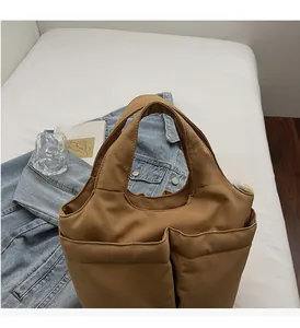 Detail view of brown multi-pocket tote bag with durable handles and spacious interior
