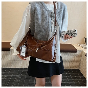 Detail of vintage brown oil wax leather bag featuring a Lazy Breeze tag and metal zipper