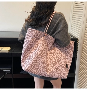 Detailed view of pink leopard print canvas tote bag with slim shoulder straps and logo tag