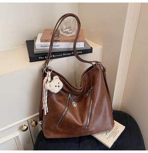 Détail du sac cabas marron vintage avec fermetures éclair et pendentif ours peluche
