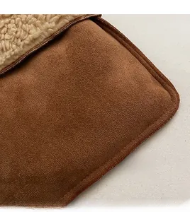 Detalle macro de gamuza marrón con forro de borreguito sintético y cremallera metálica