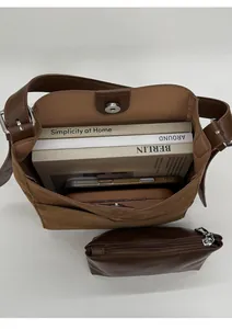 Détail de l'intérieur du sac seau marron montrant l'espace et la pochette assortie