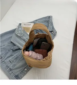 Top-down view of a spacious beige canvas tote bag with daily essentials inside