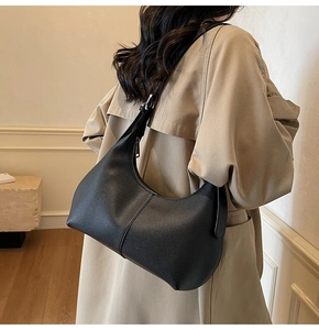 Detailed texture of black pebbled leather hobo bag with adjustable silver buckle strap