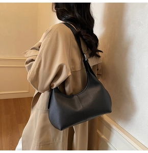 Detailed view of the black lychee grain texture and silver buckle on this hobo bag