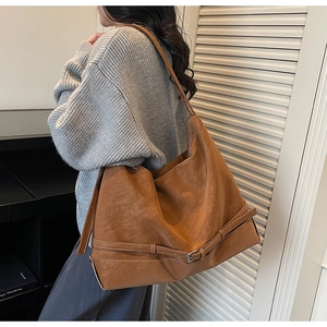Dettaglio della grande borsa tote in pelle scamosciata marrone con fibbia in metallo