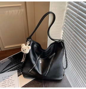 Détail du sac cabas en simili cuir noir avec poches zippées et pendentif ours en peluche