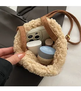 Vista interior del bolso cubo de peluche camel con espacio para el móvil y cosméticos